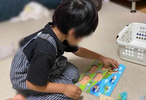 ぼんちょが1人でパズルをする写真