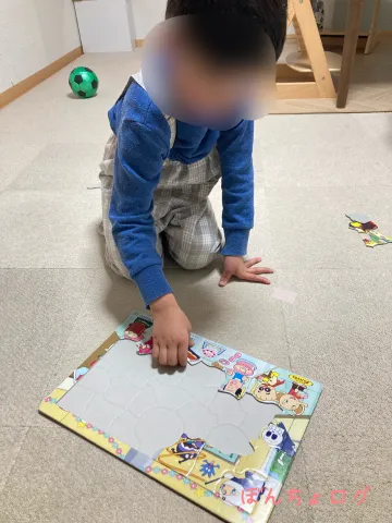 アンパンマンのパズルをはめようとするぼんちょの写真